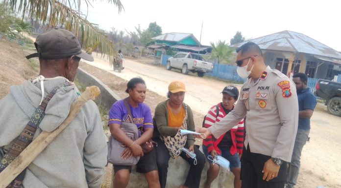 Antisipasi Dampak Asap dan Debu Karhutla, Kapolsek Babo Bagikan Masker ke Warga Sumuri